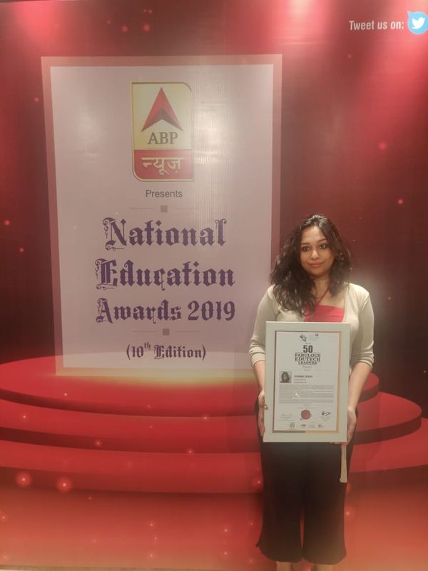 Surabhi Dewra holding a 50 Fabulous EdTech Leaders certificate in front of the National Education Awards 2019 backdrop
