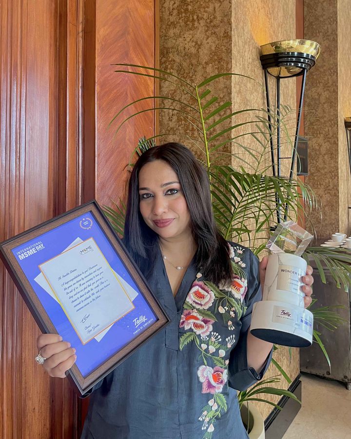 Surabhi Dewra, founder of CareerGuide.com, holding an award certificate and trophy